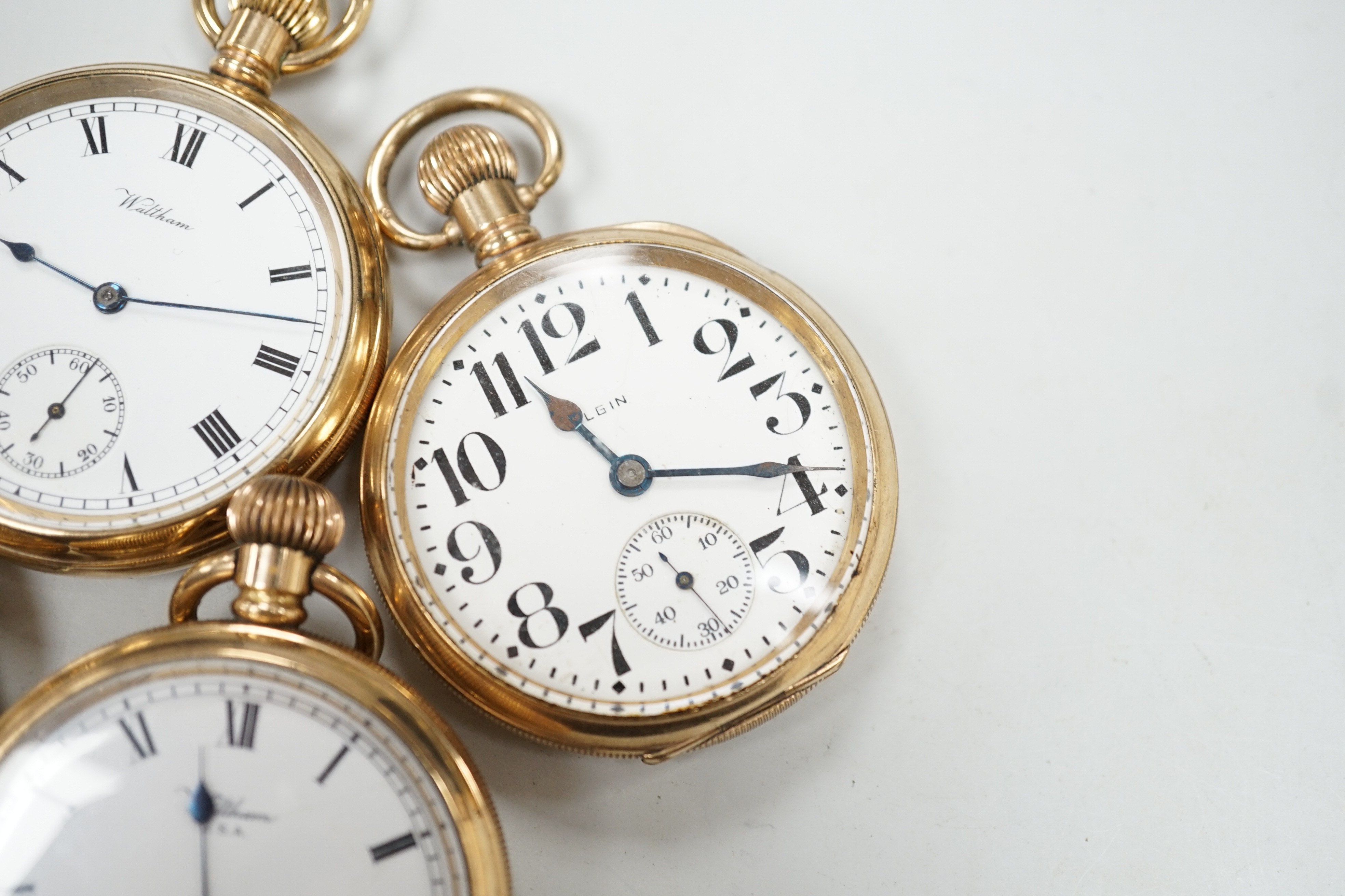 Three assorted gold plated Waltham open faced pocket watches and a similar Elgin pocket watch.